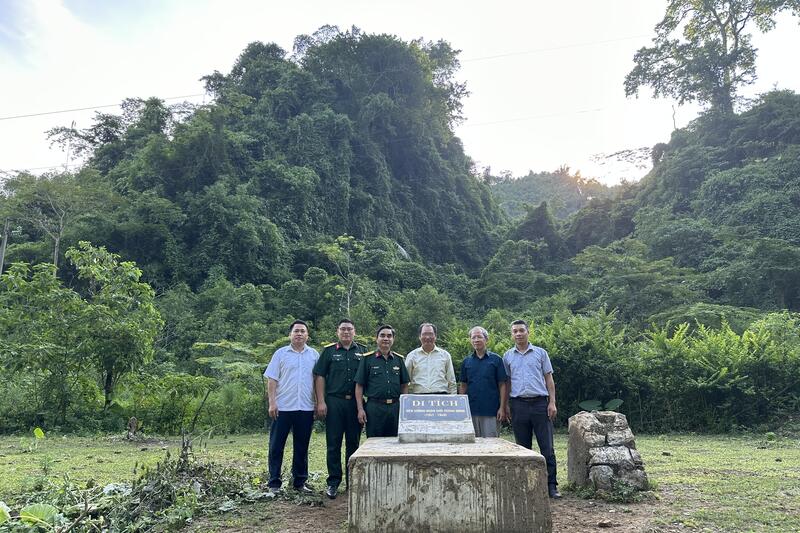 Du khách chụp ảnh lưu niệm với lãnh đạo xã Bản Thi tại điểm di tích Xưởng Quân giới, thôn Hợp Tiến, xã Bản Thi- Ảnh Hà Tuyết