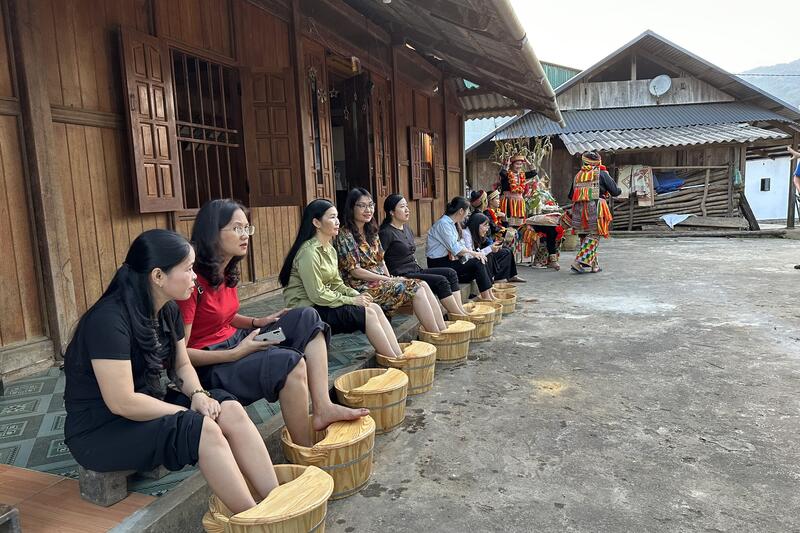Du khách trải nghiệm ngâm chân bằng thảo dược truyền thống của Người Dao tại điểm du lịch Văn hóa Bản Cuôn ( Tác giả: Hà Tuyết)